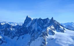 a mountain range covered in snow under a blue sky — Photo Eric BARBEAU / Unsplash