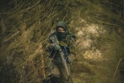 Russian soldier running towards camera in the forest. — Photo Dominik Sostmann / Unsplash