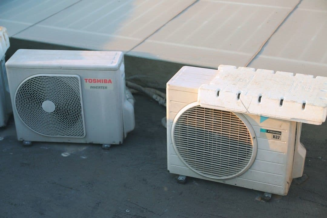 a couple of air conditioners sitting next to each other — Photo Bùi Hoàng Long / Unsplash
