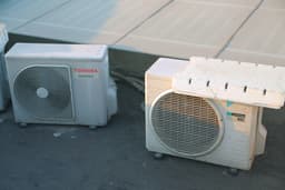 a couple of air conditioners sitting next to each other — Photo Bùi Hoàng Long / Unsplash