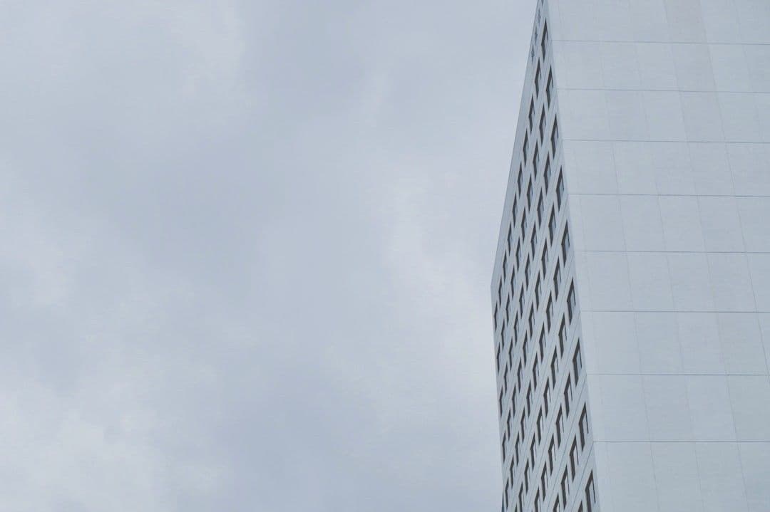 grey skyscraper front in front of a grey sky — Photo Jonas Gerlach / Unsplash