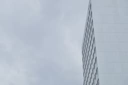 grey skyscraper front in front of a grey sky — Photo Jonas Gerlach / Unsplash