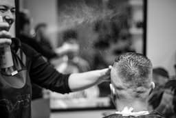 a man getting his hair cut at a barber shop — Photo Gabriela / Unsplash