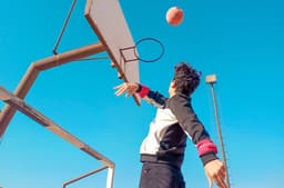a man is playing basketball on a basketball court — Photo Moustafa Neamatalla / Unsplash