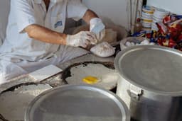 a man in a white shirt and some metal pans — Photo Michael Wave / Unsplash