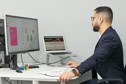 a man sitting at a desk with a laptop and a computer — Photo ZBRA Marketing / Unsplash