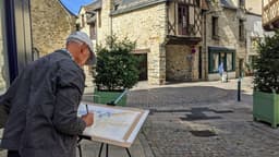 Dans le cœur de ville de Châteaubriant, un peintre amateur tente de reproduire les maisons à colombages. — Photo Alain Moreau / Unsplash