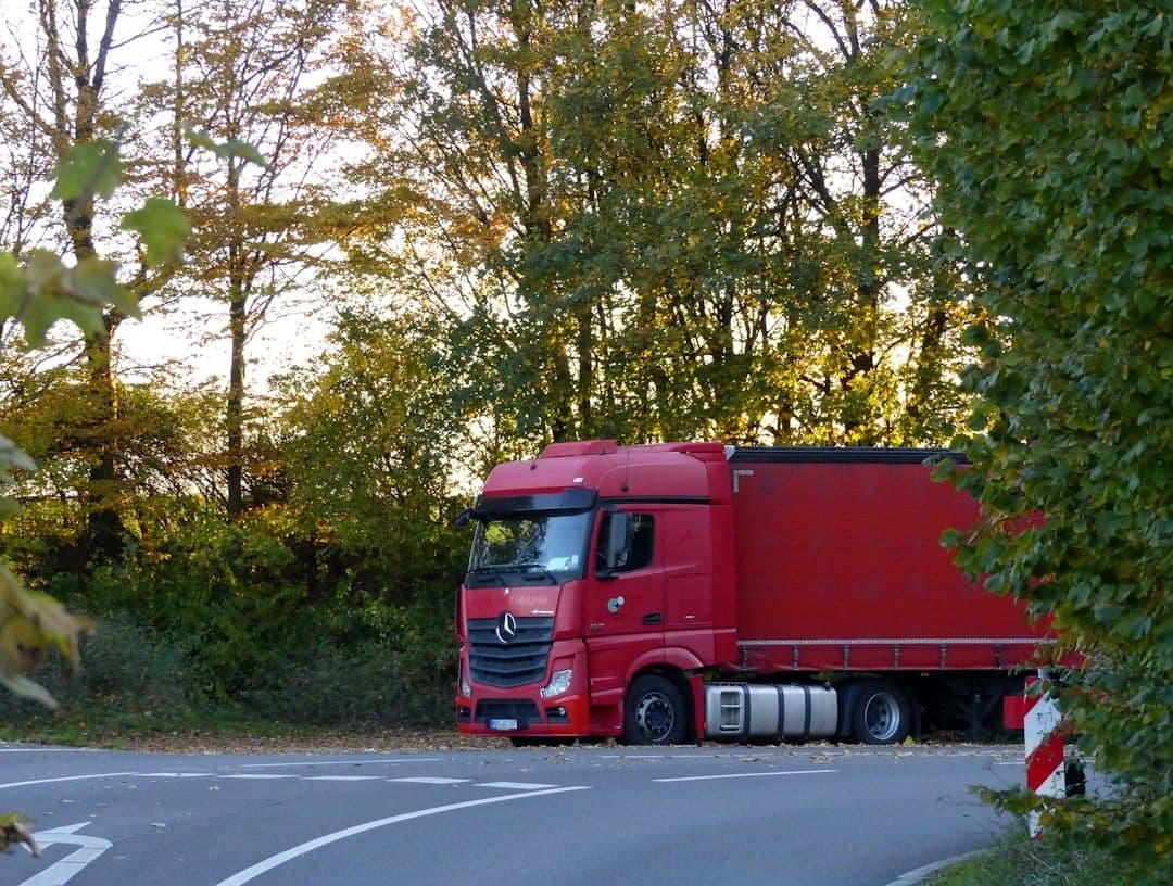 a red truck is parked on the side of the road — Photo Jack Blueberry / Unsplash