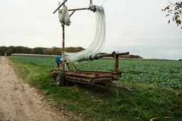 a truck with a net on the back of it driving down a dirt road — Photo Mathias Reding / Unsplash