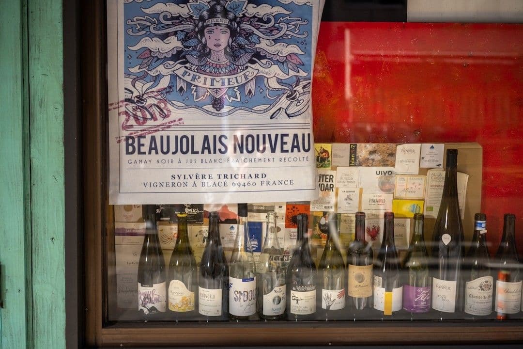 a bunch of bottles of wine on display behind a glass — Photo Kouji Tsuru / Unsplash