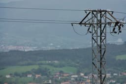 a view of a power line with a city in the background — Photo Pablo Sanchez Cuesta / Unsplash