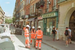 a group of construction workers standing on the side of a road — Photo luca booth / Unsplash