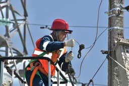 a man in safety gear working on a power pole — Photo Антон Дмитриев / Unsplash