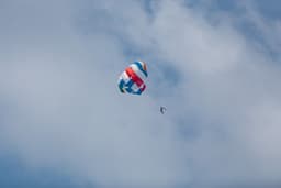 red yellow and blue parachute in the sky — Photo Maahid Photos / Unsplash