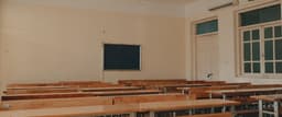 an empty classroom with desks and a chalkboard — Photo Nguyen Phan Nam Anh / Unsplash