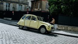 A classic yellow car on a cobblestone street. — Photo Cande Westh / Unsplash