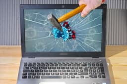 a person holding a pencil and a broken laptop — Photo Immo Wegmann / Unsplash