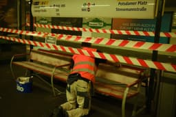 a man in an orange safety vest working on a bench — Photo Alan Alves / Unsplash