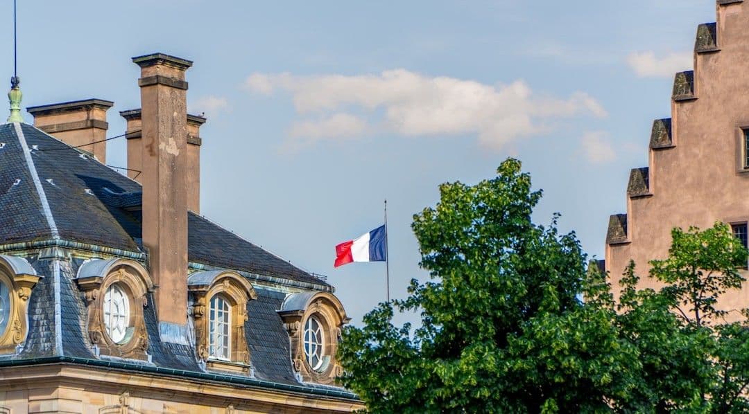This photo was taken in the square outside Strasbourg Cathedral, and shows a French flag, not quite at full height. — Photo Ed Wingate / Unsplash