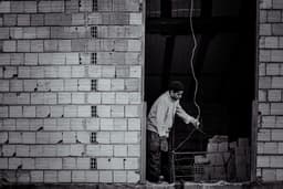 man in white dress shirt and pants holding a stick — Photo Alireza Zarafshani / Unsplash