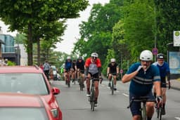 Cyclists ride their bikes down a road. — Photo peter jochim / Unsplash