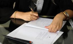 a person writing on a piece of paper — Photo Mana Akbarzadegan / Unsplash