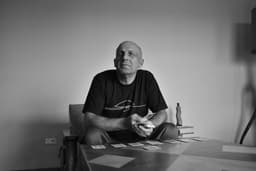 man in black crew neck t-shirt sitting on chair — Photo Juan I. Riera / Unsplash