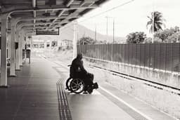 grayscale photo of person sitting on wheelchair — Photo Igor Rodrigues / Unsplash