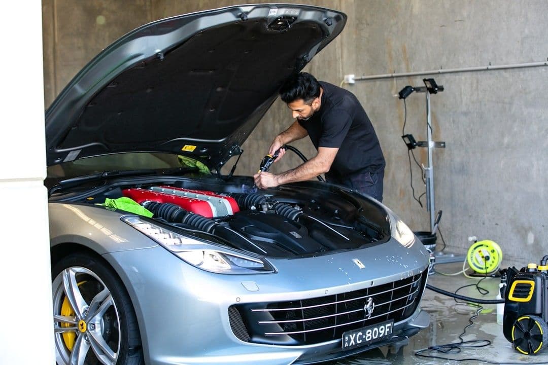 A mechanic is working on a ferrari car. — Photo Fine Automotive Detailing / Unsplash