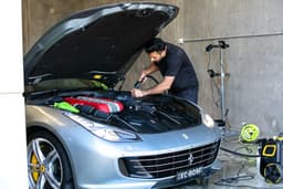 A mechanic is working on a ferrari car. — Photo Fine Automotive Detailing / Unsplash