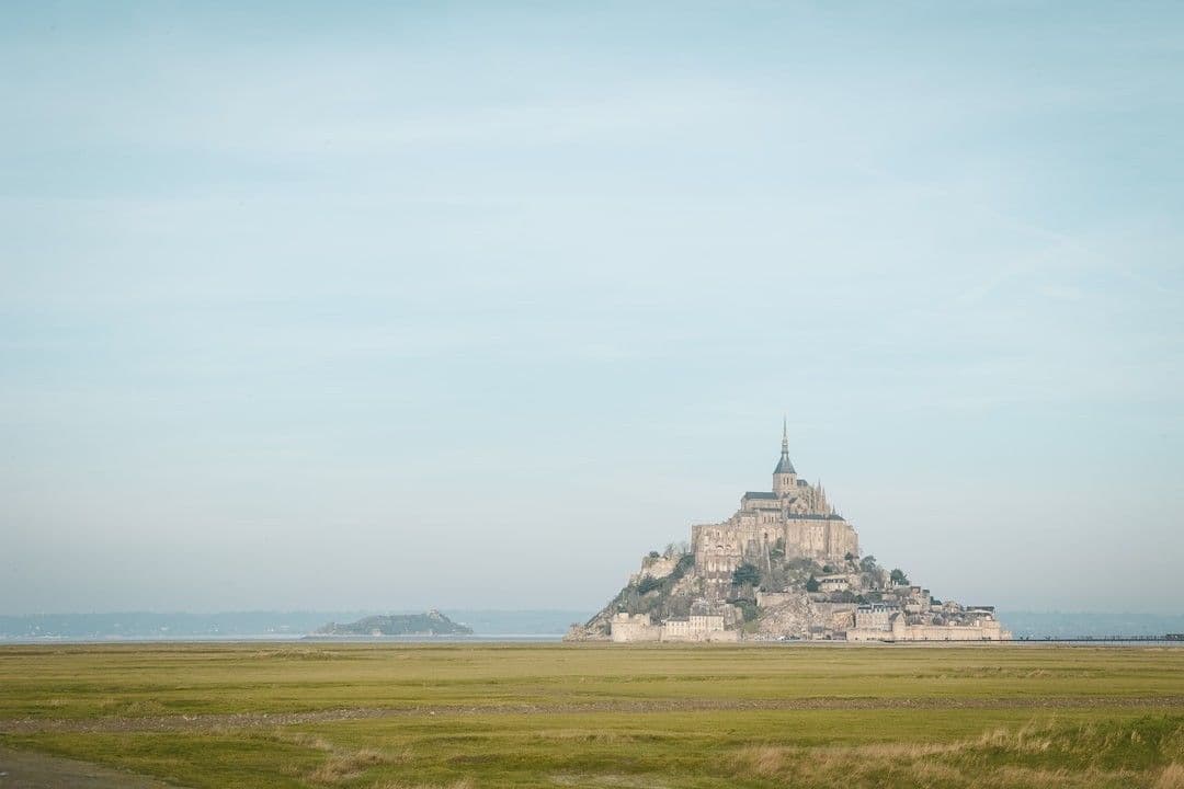 Mont Saint Michel in France under blue and white sky — Photo Aurora Borealis / Unsplash