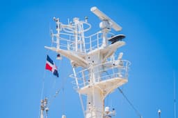 Ship's radar mast with dominican republic flag — Photo Aldward Castillo / Unsplash