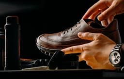 a person tying a pair of brown shoes — Photo Amr Taha™ / Unsplash