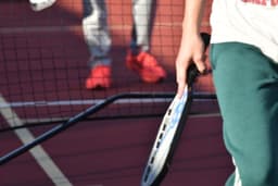 Pickleball players on court with close up of paddle — Photo Lesli Whitecotton / Unsplash