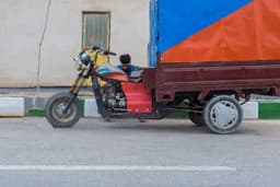 a man riding on the back of a motorcycle next to a truck — Photo Javad Esmaeili / Unsplash