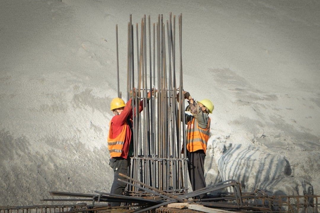 two men working on a construction site — Photo Yk K / Unsplash
