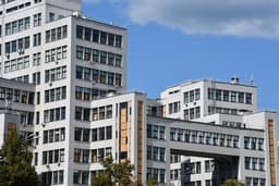 Modern white office buildings against blue sky — Photo Scar Tissue / Unsplash