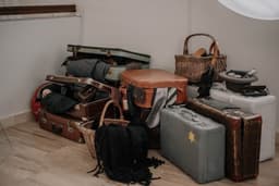 a pile of luggage sitting on top of a hard wood floor — Photo Carlos Derecichei / Unsplash