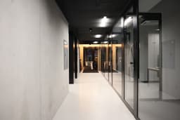 a long hallway with glass walls and a white floor — Photo Iggy Love / Unsplash