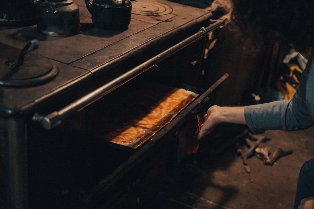 a woman is putting food in an oven — Photo gaspar zaldo / Unsplash
