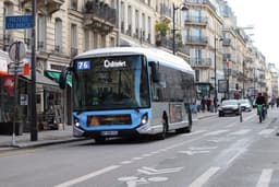 A bus is driving on a city street. — Photo Nathan Cima / Unsplash