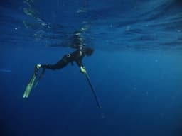 a person in a wet suit is in the water — Photo Her Pratam / Unsplash
