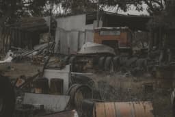A junk yard filled with abandoned vehicles. — Photo Ewan Z / Unsplash