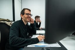 Two people working at computers in a technical office, reviewing documentation and technical drawings. — Photo TECNIC Bioprocess Solutions / Unsplash