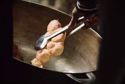 a person scooping some food out of a frying pan — Photo Danielle-Claude Bélanger / Unsplash