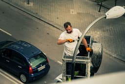 man in white dress shirt and black pants sitting on yellow and black steel cart — Photo Jose Antonio Gallego Vázquez / Unsplash
