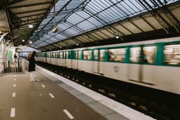 a person standing on a platform next to a train — Photo Mathias Reding / Unsplash