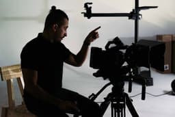 a man sitting on a chair in front of a camera — Photo Alvis Wolff / Unsplash