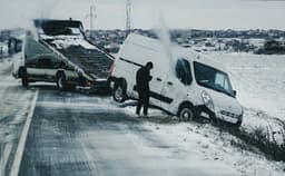 a man standing next to a white van on the side of a road — Photo Burak Donertas / Unsplash