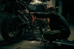 a man working on a motorcycle in a garage — Photo Angry._.Kat / Unsplash